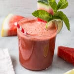 watermelon smoothie with watermelon mint and lime garnishes in glasses