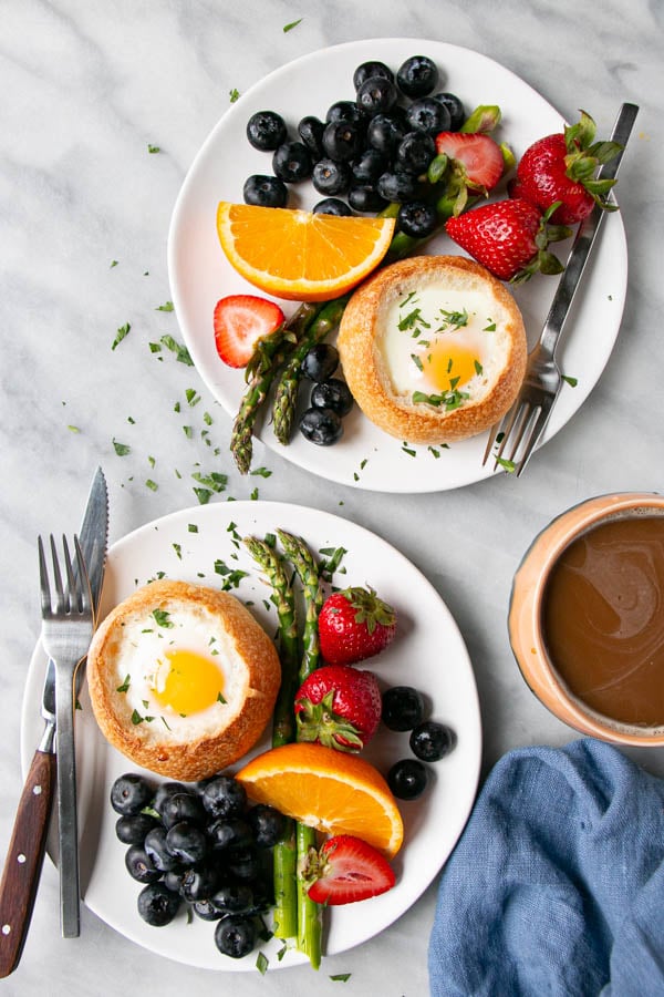 Oven Baked Eggs in Buns with bright berries, oranges, and asparagus.