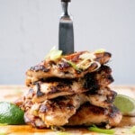 Deeply browned Lemongrass Chicken in a tall stack with a wooden handled knife down the centre.