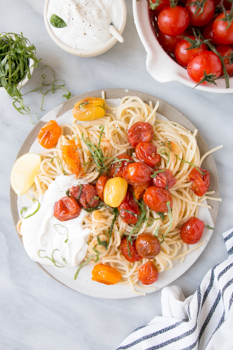 Summer Tomato Basil Pasta with bright red cherry tomatoes, long spaghetti pasta, and a dollop of creamy smooth ricotta