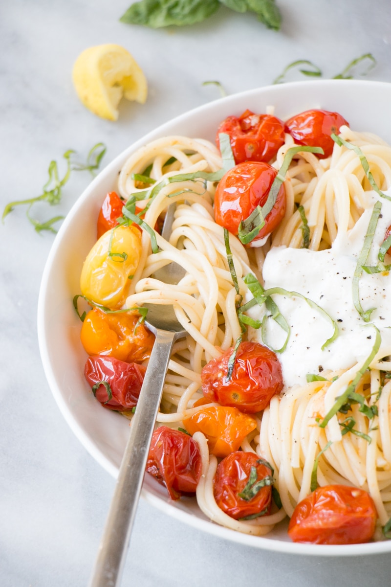 Summer Tomato Pasta with bright red cherry tomatoes, long spaghetti pasta, and a dollop of creamy smooth ricotta