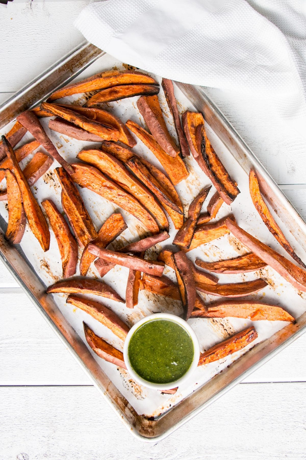Roasted Sweet Potatoes with Chimichurri is a vibrant and delicious side dish! Super healthy with baked sweet potato fries and herb packed chimichurri sauce. #healthy #sweetpotatoes #fries #chimichurri