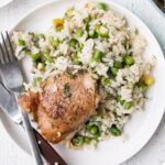 One Pot Chicken and Rice with Peas and Dill in a large pot served on a white plate