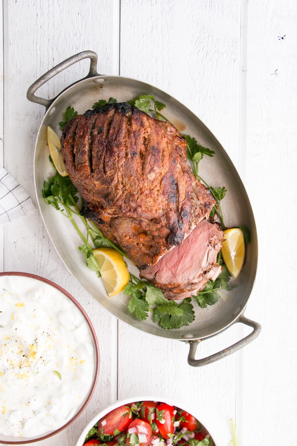 Curry spiced leg of lamb, partially sliced in a serving dish