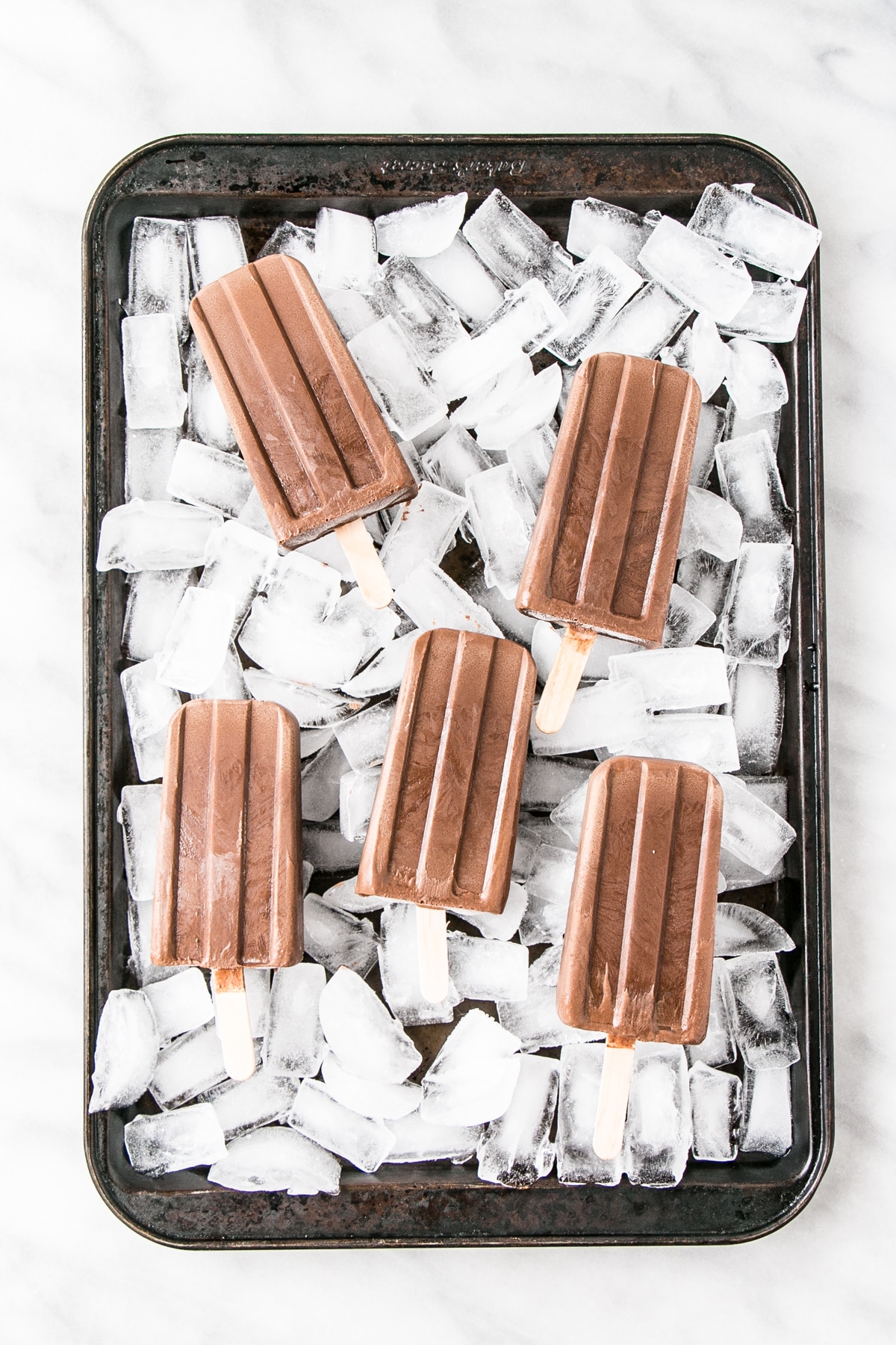 Healthier Homemade Fudgsicles on top of ice.