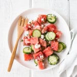 Watermelon Salad on a white plate with a wood fork