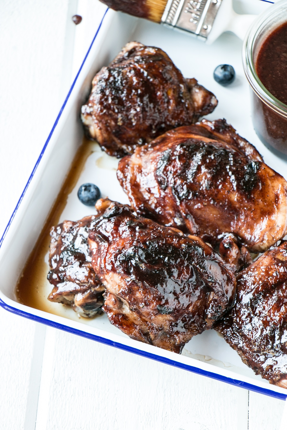 Slow Cooker Blueberry BBQ Sauce with grilled chicken with the sauce on it.