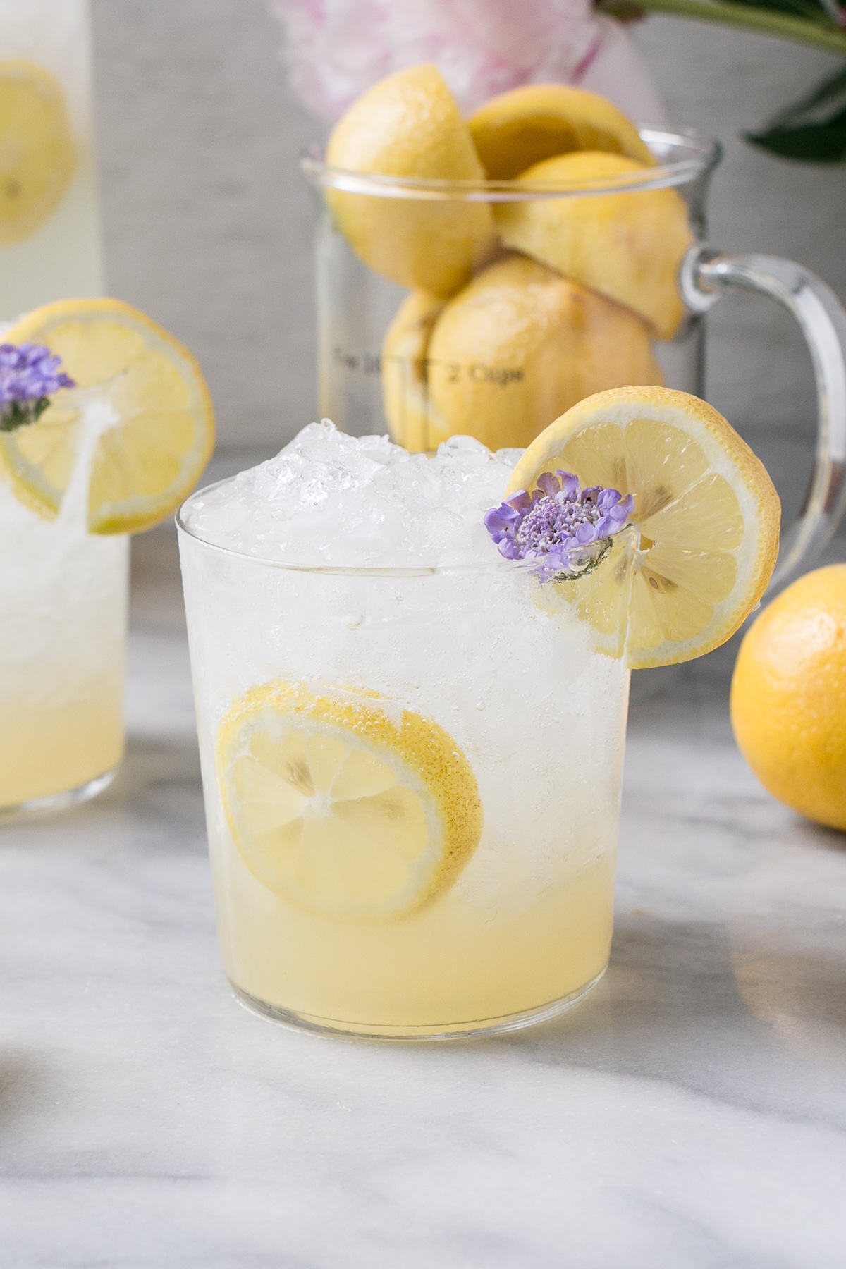 Sugar-Free Lemonade in glasses with lemon slices and a small purple flowers.