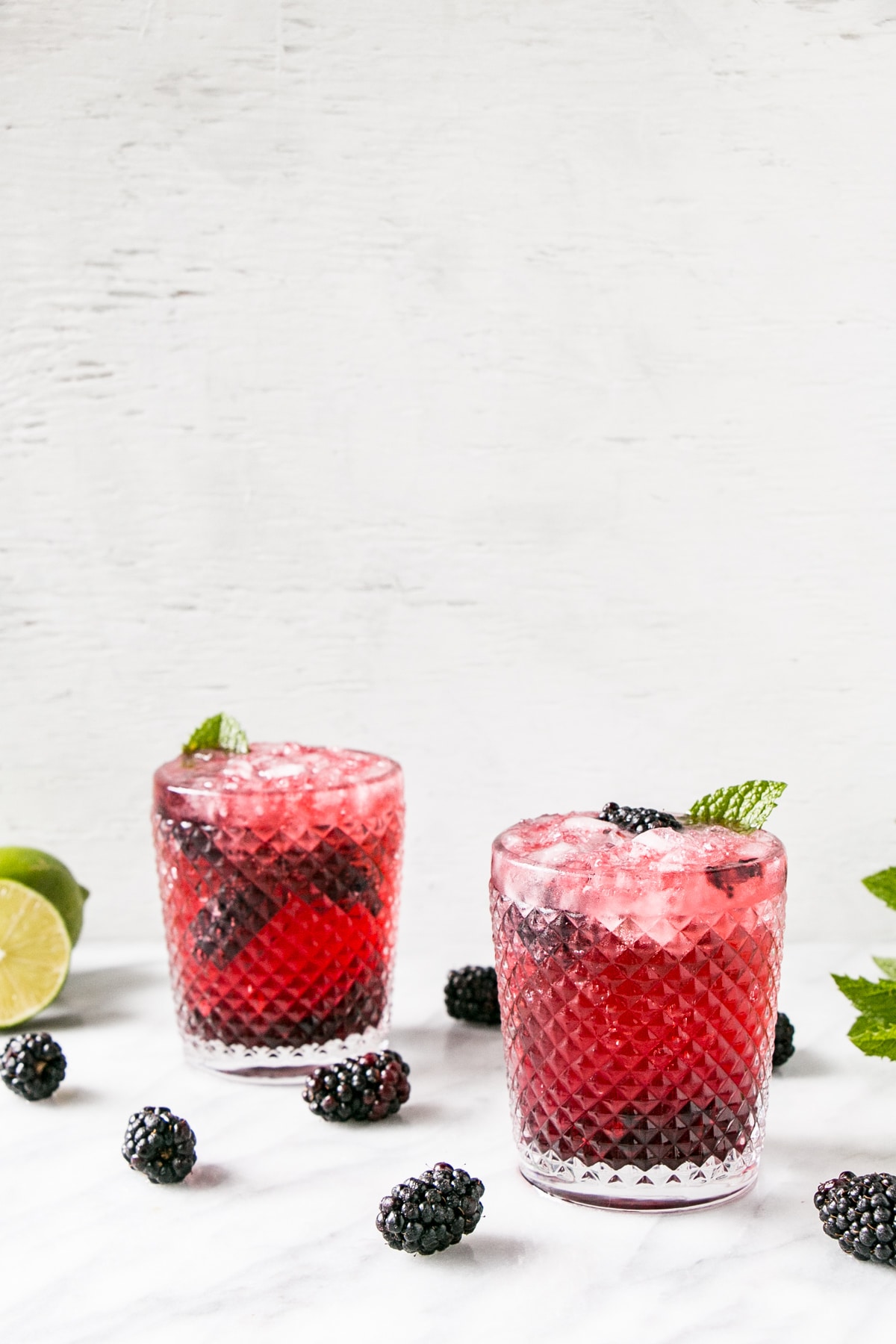Blackberry Mojito in a textured glass with blackberries, lime and mint. 