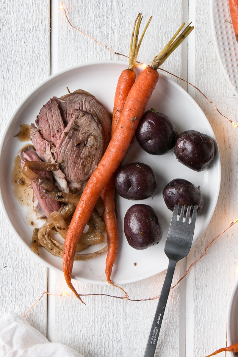 Holiday Lamb Roast sliced with potatoes and carrots