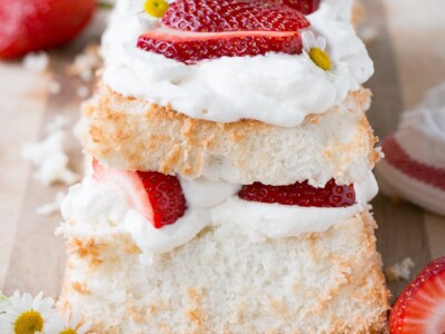 Strawberry Angel Food Cake close up of the end of a loaf angel food cake layered with whipped cream and strawberries.