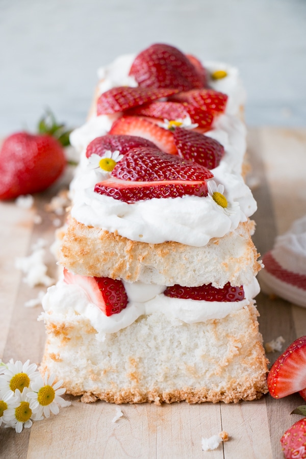 Loaf pan angel food cake layered with whipping cream and strawberries. 