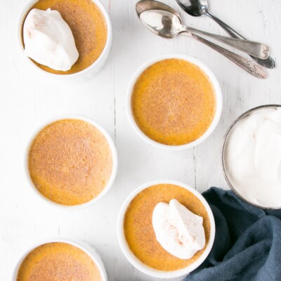 Deep golden Pumpkin Egg Custard with a dollop of whipping cream and a light sprinkle of cinnamon.