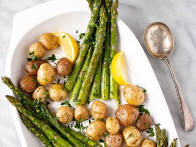 Roasted Potato and Asparagus with lemon slices on a white serving plate.