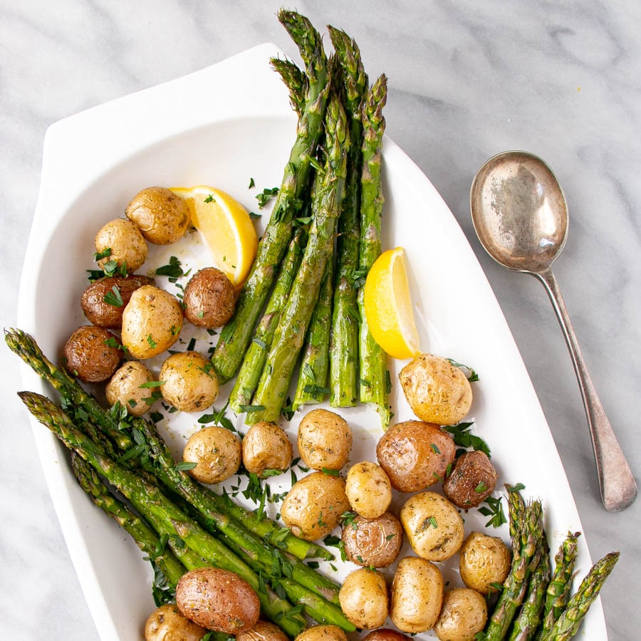 Roasted Potato and Asparagus with lemon slices on a white serving plate.