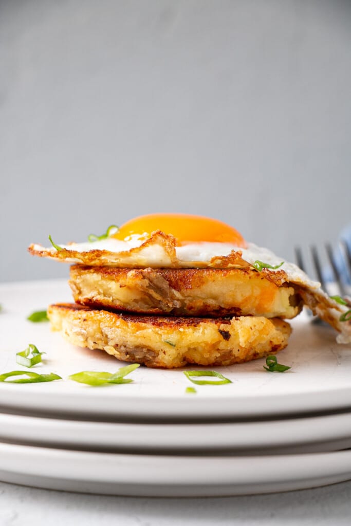 Leftover Mashed Potato Pancakes in a stack with a crispy edged cooked soft fried egg.
