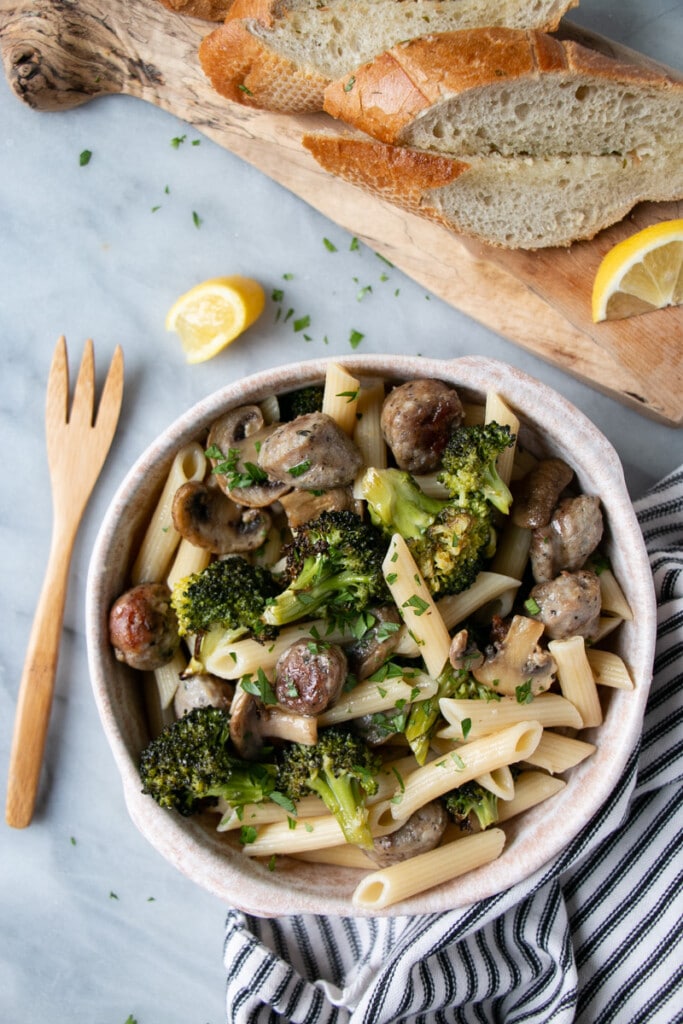 Roasted Sausage and Broccoli Pasta with squeezed lemon slices and toasted sliced garlic bread.
