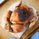 Slow Cooker Roast Chicken with crispy dark golden brown skin on a baking sheet.